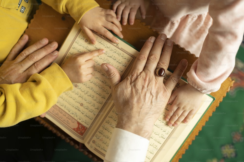 a group of people holding hands over a book