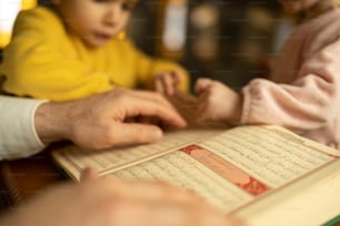 a person holding a child's hand over a book