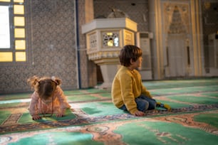 two small children sitting on a rug in a room