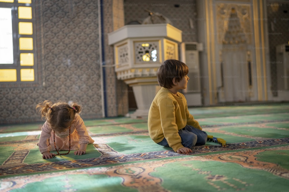two small children sitting on a rug in a room