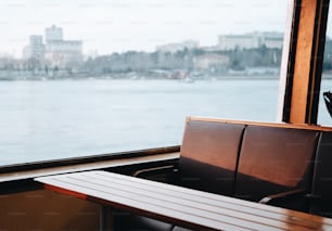 a bench sitting next to a window overlooking a body of water