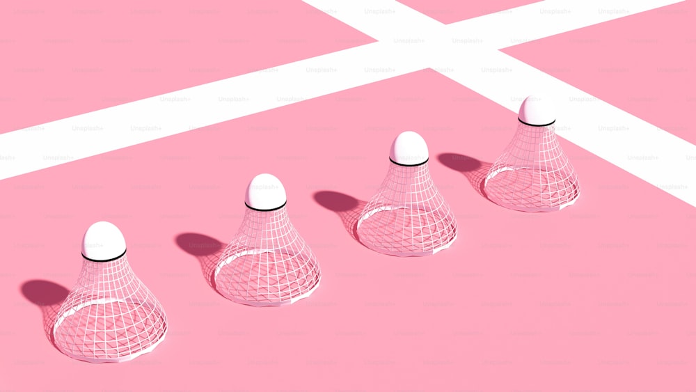 Un grupo de tres jarrones sentados sobre una superficie rosa