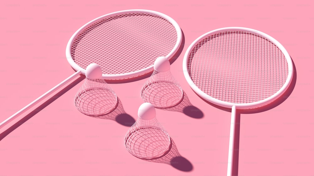 Tres raquetas de tenis rosas sobre fondo rosa