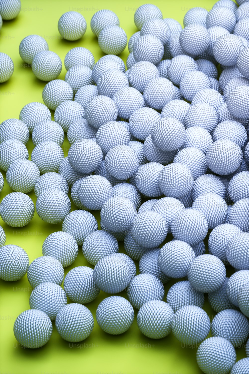 a pile of white balls sitting on top of a green surface