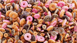 a pile of pink and black donuts and donuts on a table