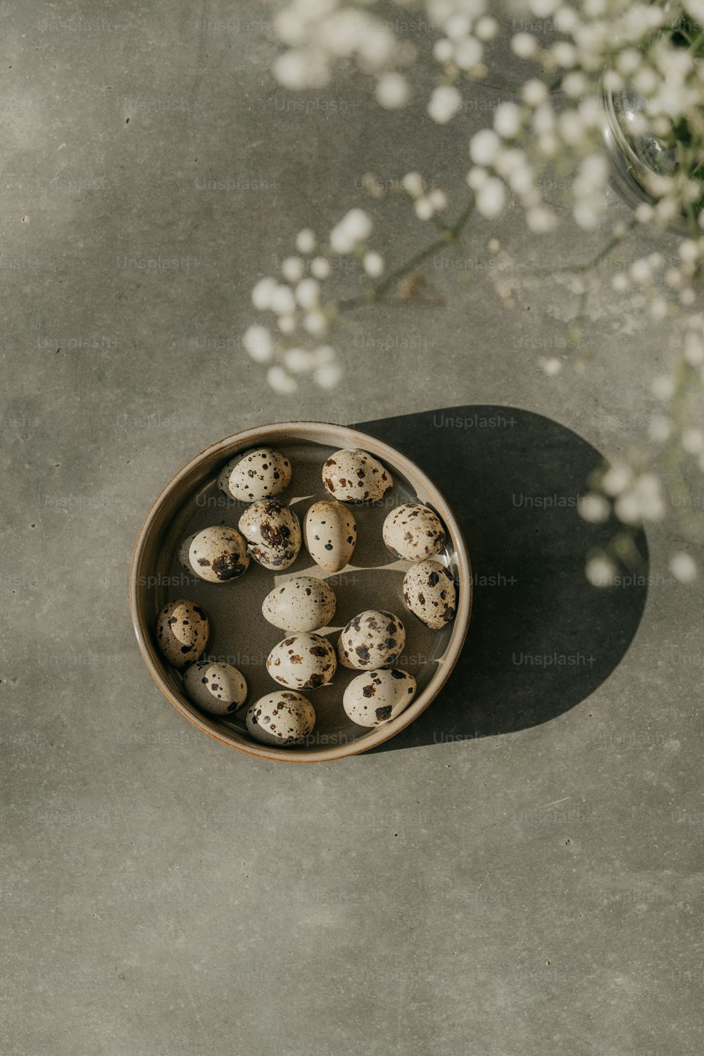 a bowl of quails on a table with flowers