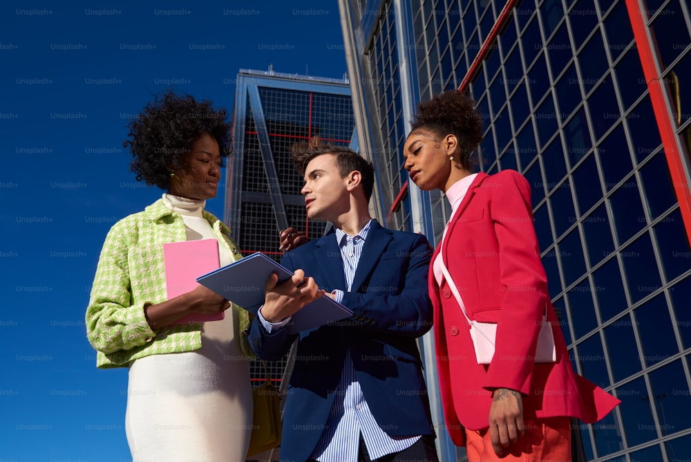 a group of people standing next to each other in front of a building