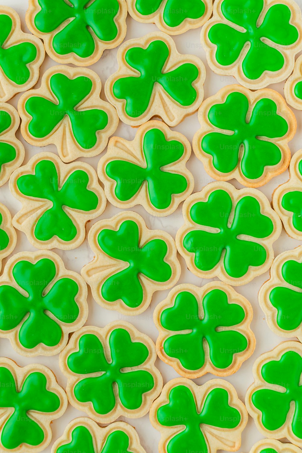 a close up of a plate of cookies with shamrock cookies