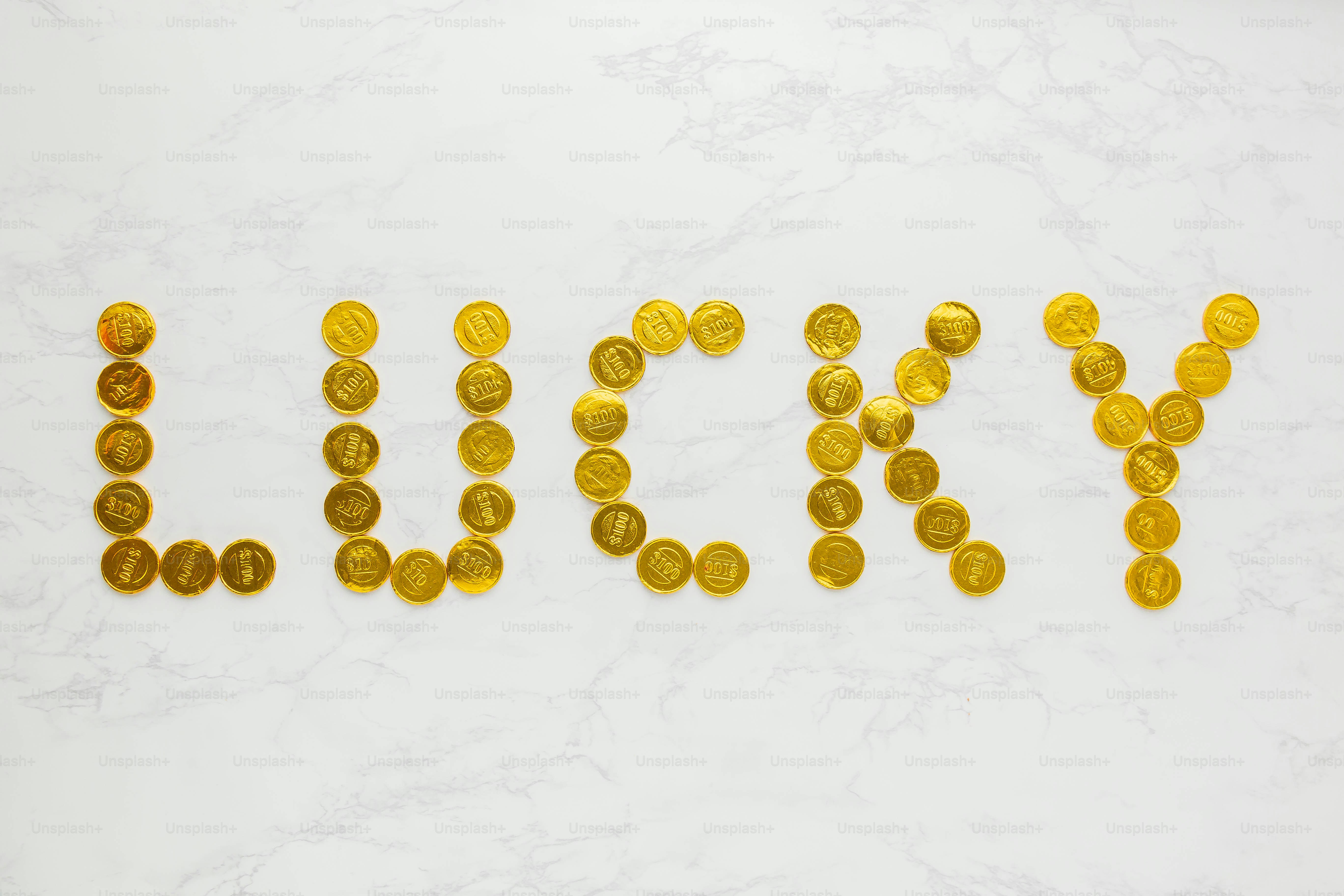 a word made out of gold coins sitting on top of a white table