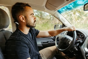 Un hombre conduciendo un coche con un volante