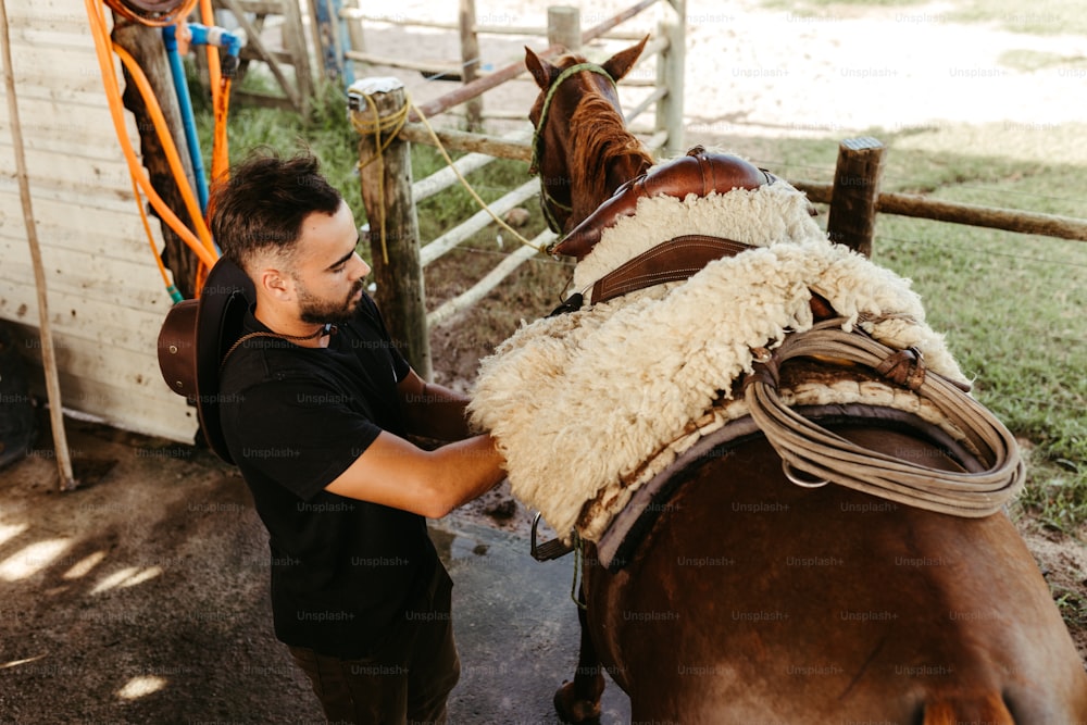 a man standing next to a brown horse