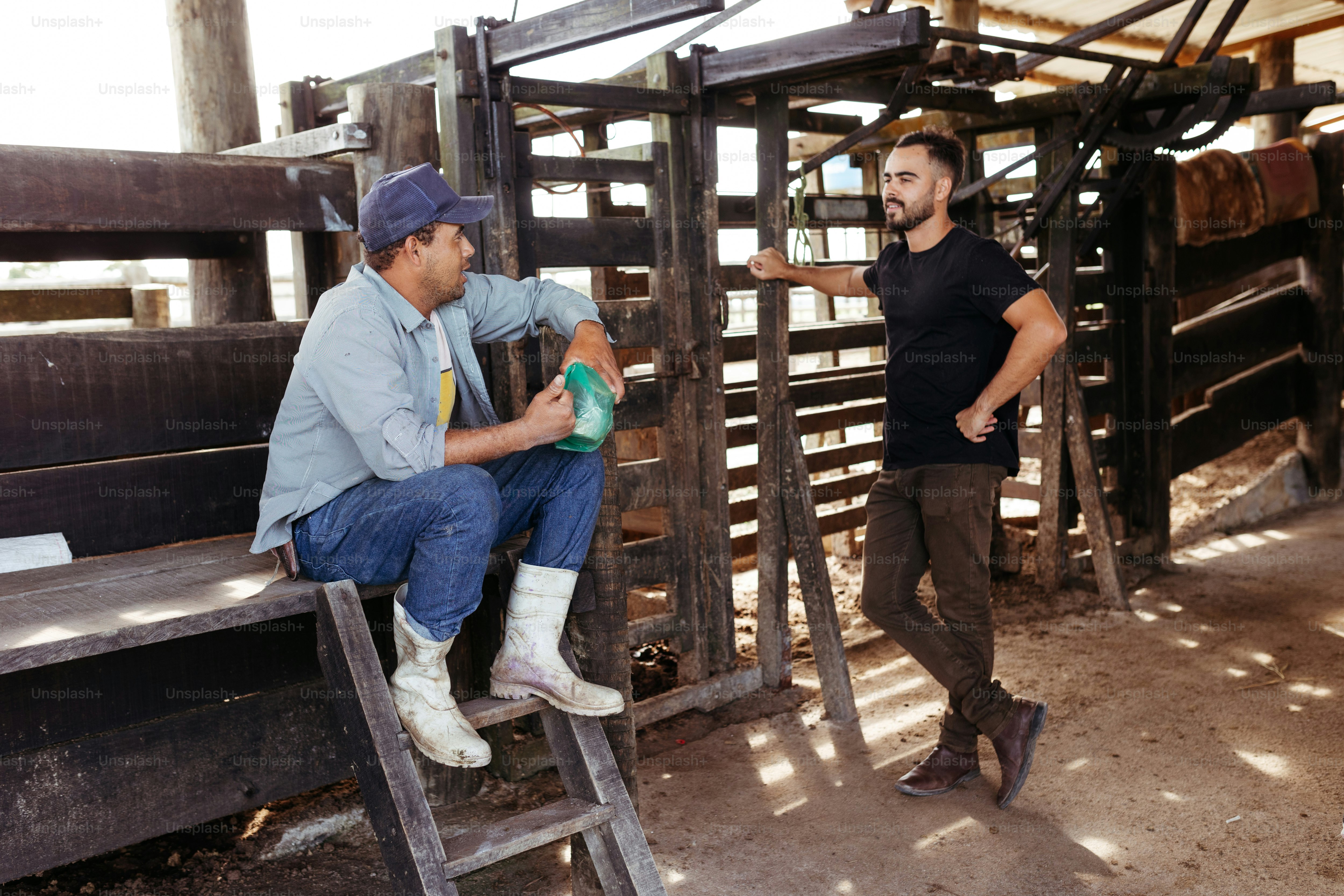 a man sitting on a wooden bench next to another man