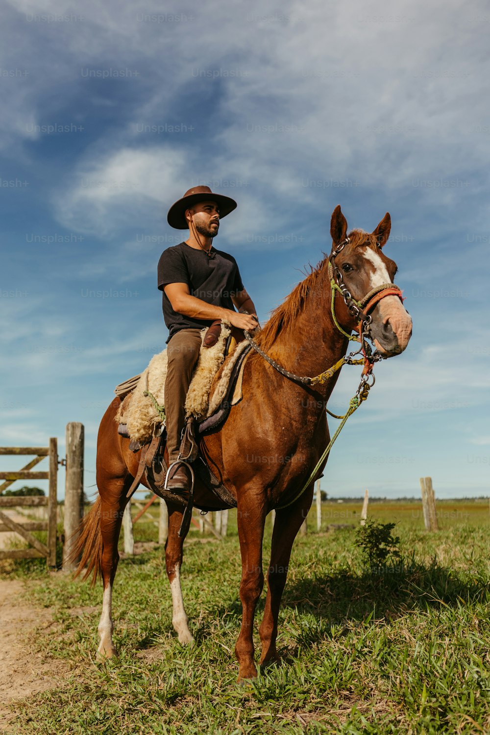 Ein Mann mit Cowboyhut reitet auf einem Pferd