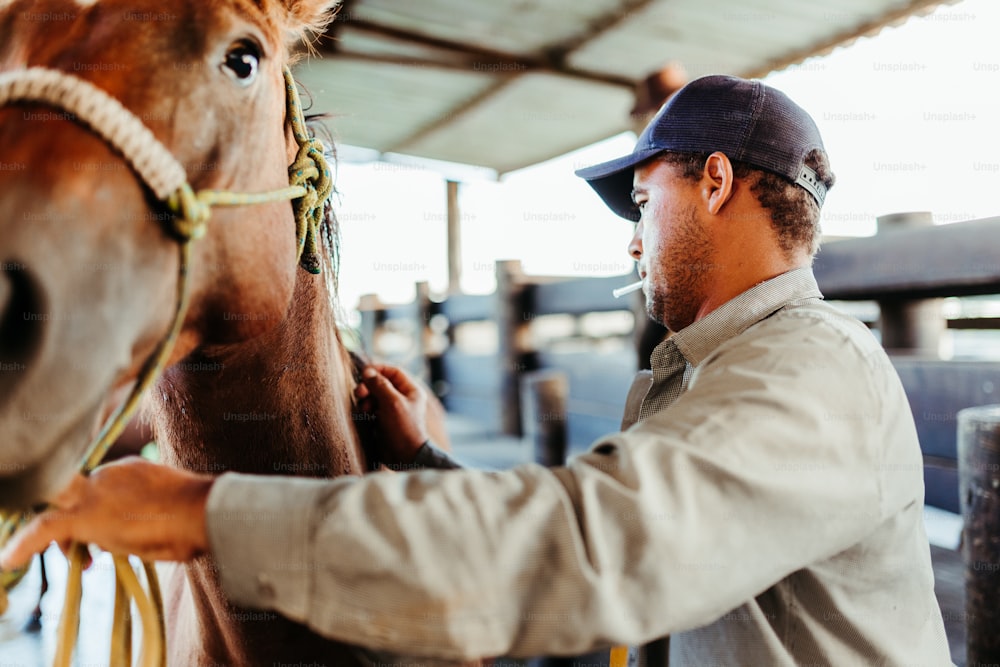 a man standing next to a brown horse