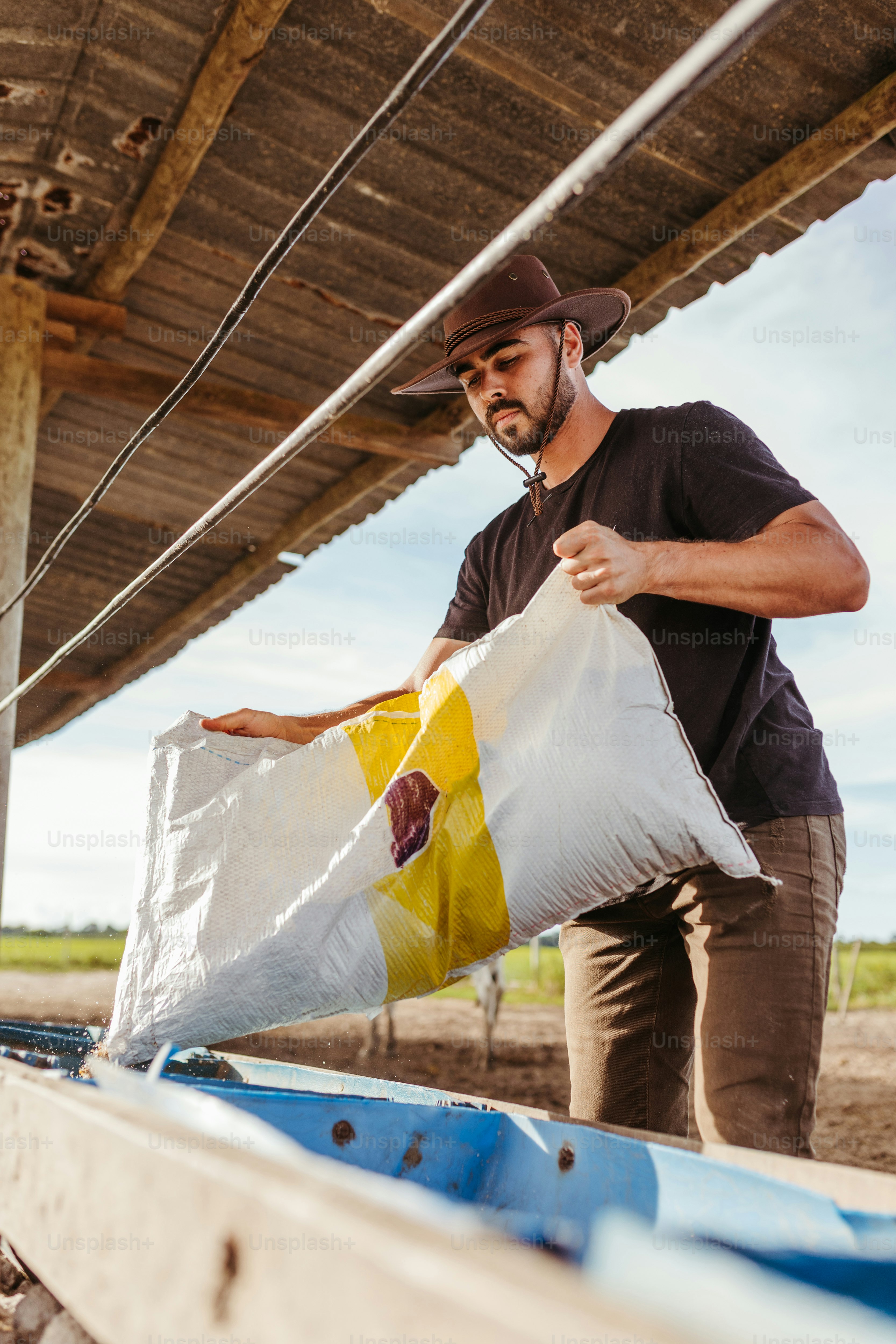 Ein Mann hält einen Sack Sand neben einem Boot