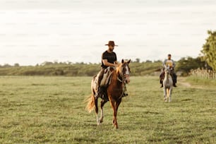 Ein Mann reitet auf einem Pferd neben einem anderen Mann auf einem Feld
