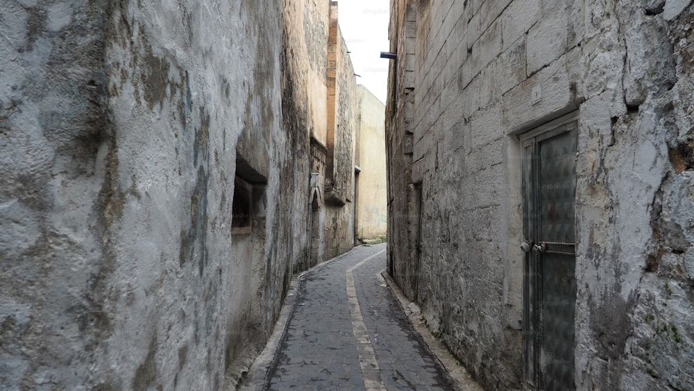 a narrow alley way with a stone building