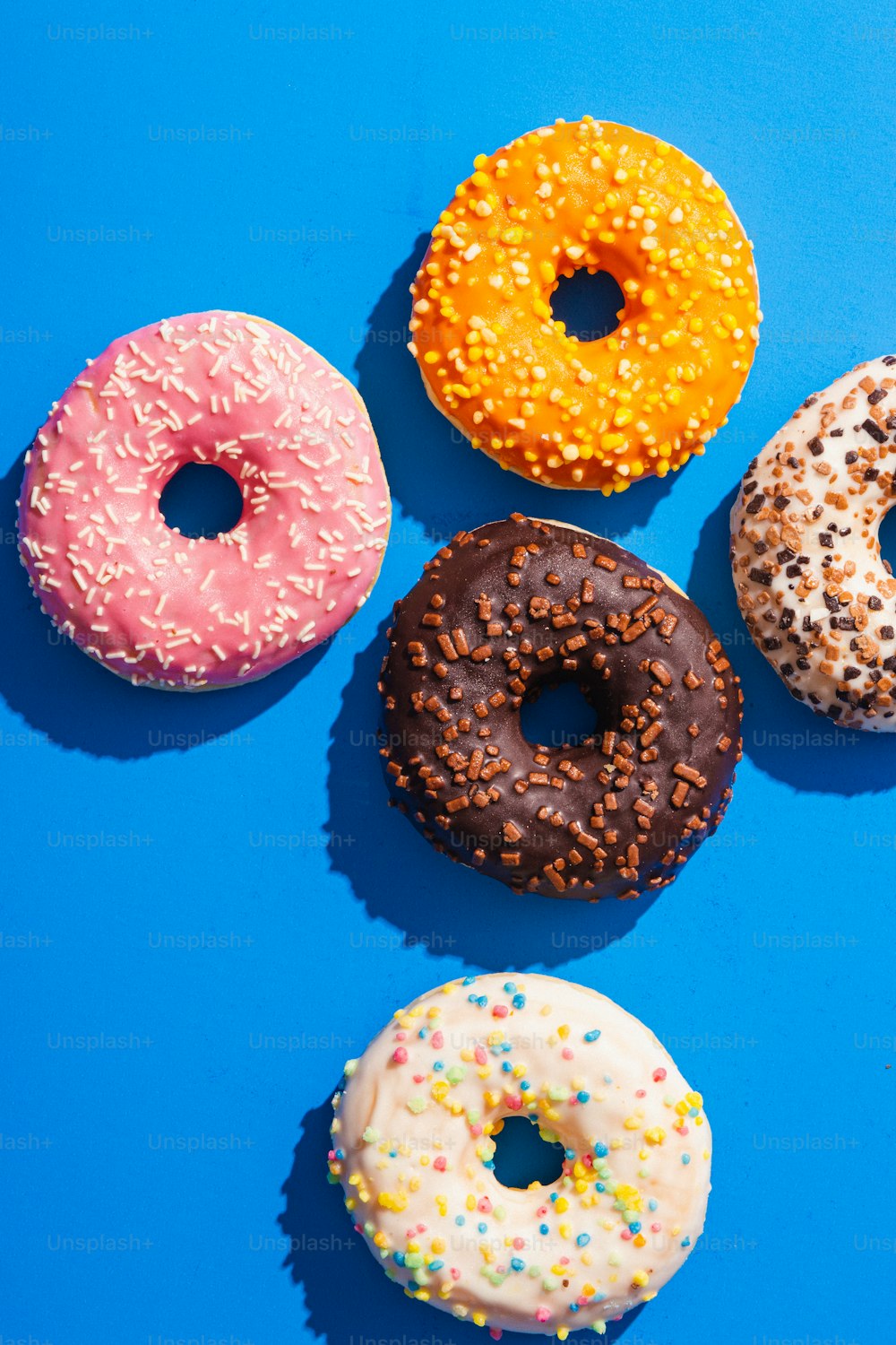 a group of four donuts sitting on top of a blue surface