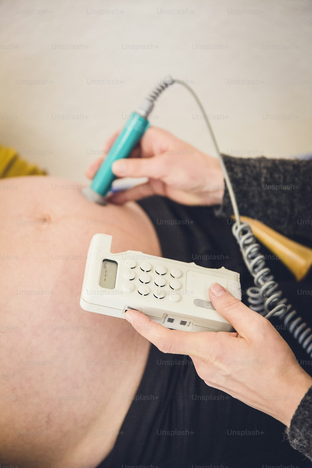 Una donna incinta che tiene un telefono e un telefono cordless