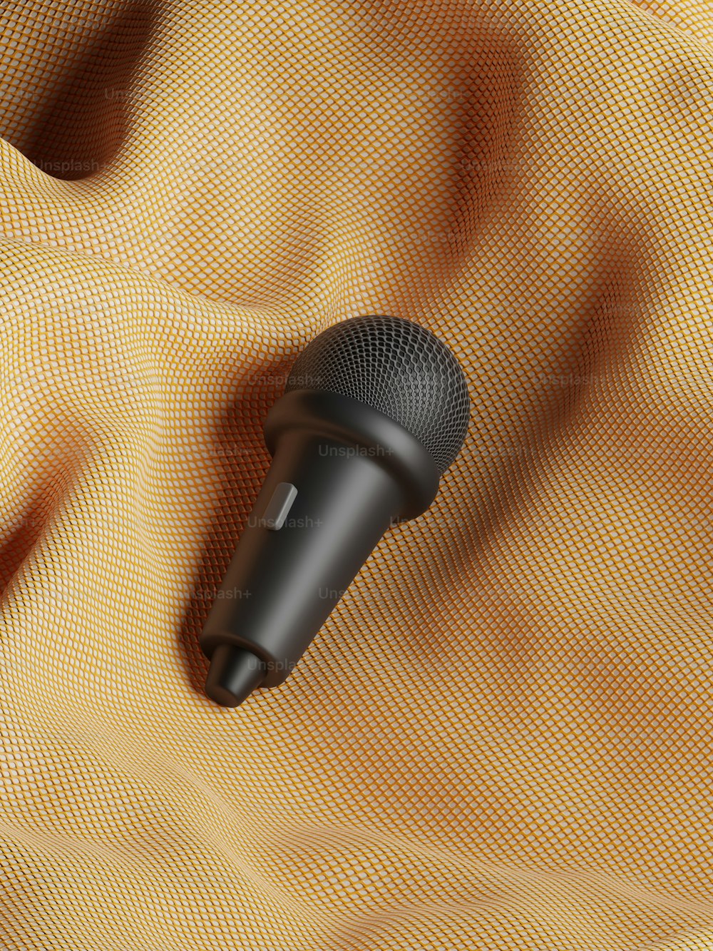 un microphone noir posé sur un tissu jaune