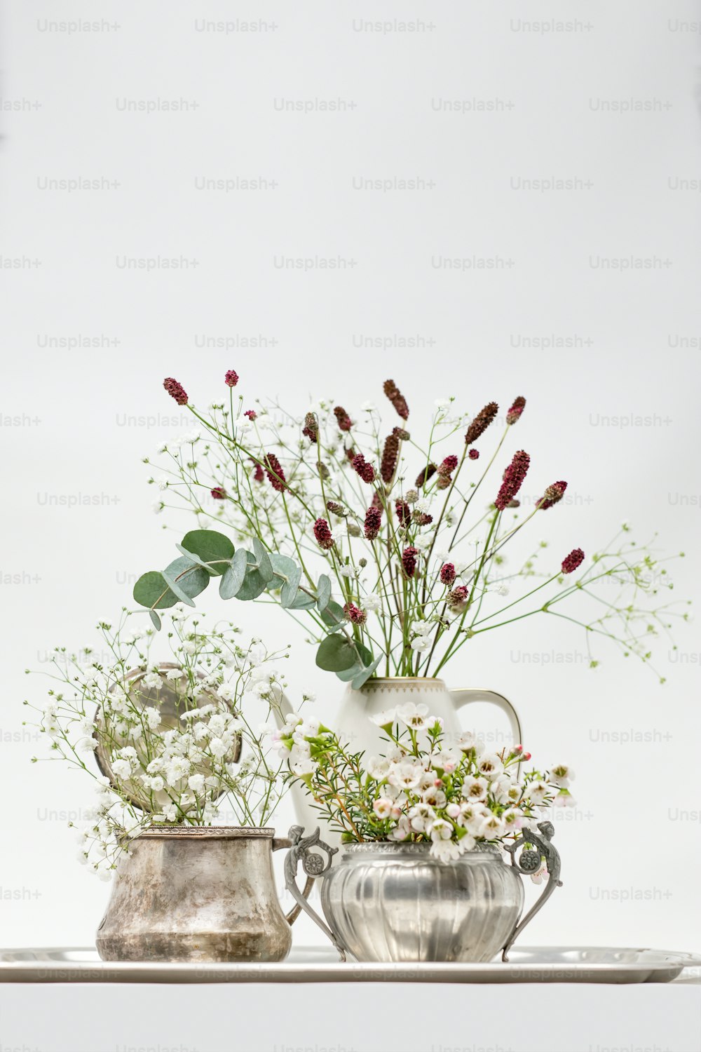 Un par de jarrones llenos de flores encima de una mesa