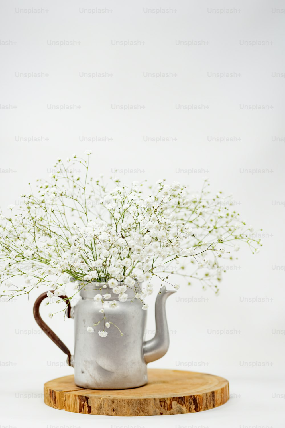 a metal watering can with flowers in it