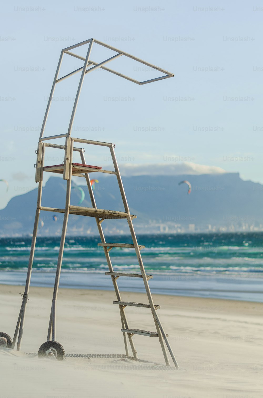 uma escada de madeira sentada no topo de uma praia de areia