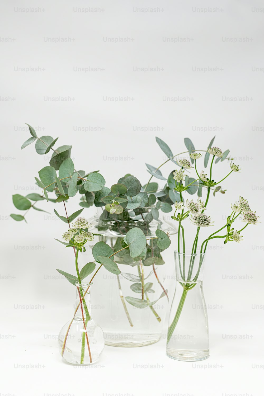 a couple of vases filled with flowers and greenery