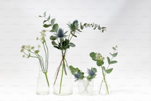 um grupo de três vasos cheios de diferentes tipos de flores