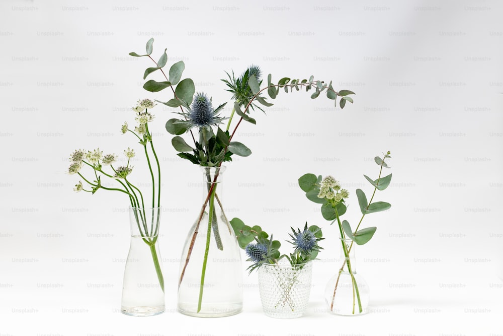 eine Gruppe von drei Vasen, gefüllt mit verschiedenen Arten von Blumen