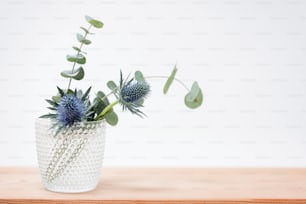 um vaso com uma planta sobre uma mesa