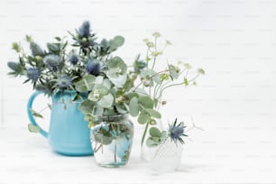 un paio di vasi pieni di fiori in cima a un tavolo