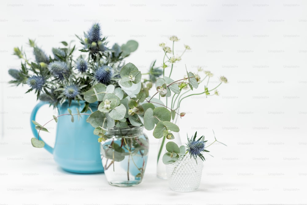 um par de vasos cheios de flores em cima de uma mesa