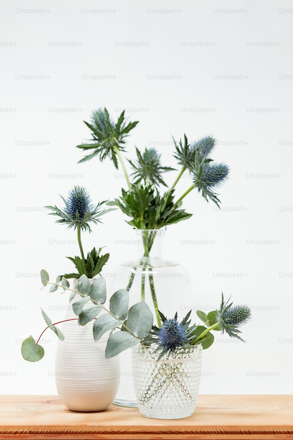 Un par de jarrones llenos de plantas encima de una mesa