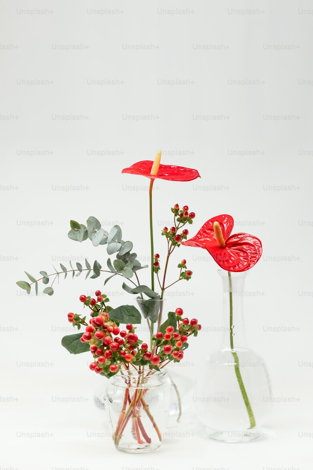 a couple of vases filled with flowers on top of a table