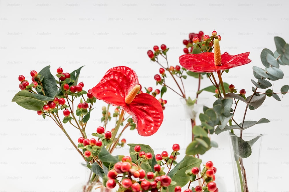 Un jarrón lleno de flores rojas y vegetación