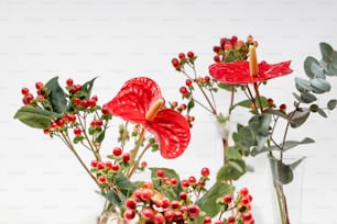 um vaso cheio de flores vermelhas e vegetação