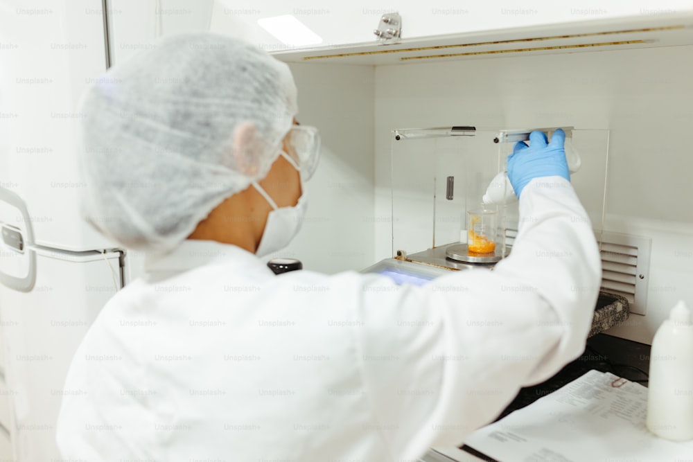 a person in a white lab coat and blue gloves