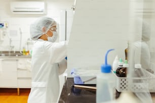 a person in a lab coat and face mask