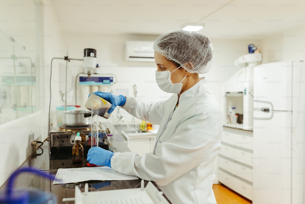 a woman in a lab wearing a mask and gloves
