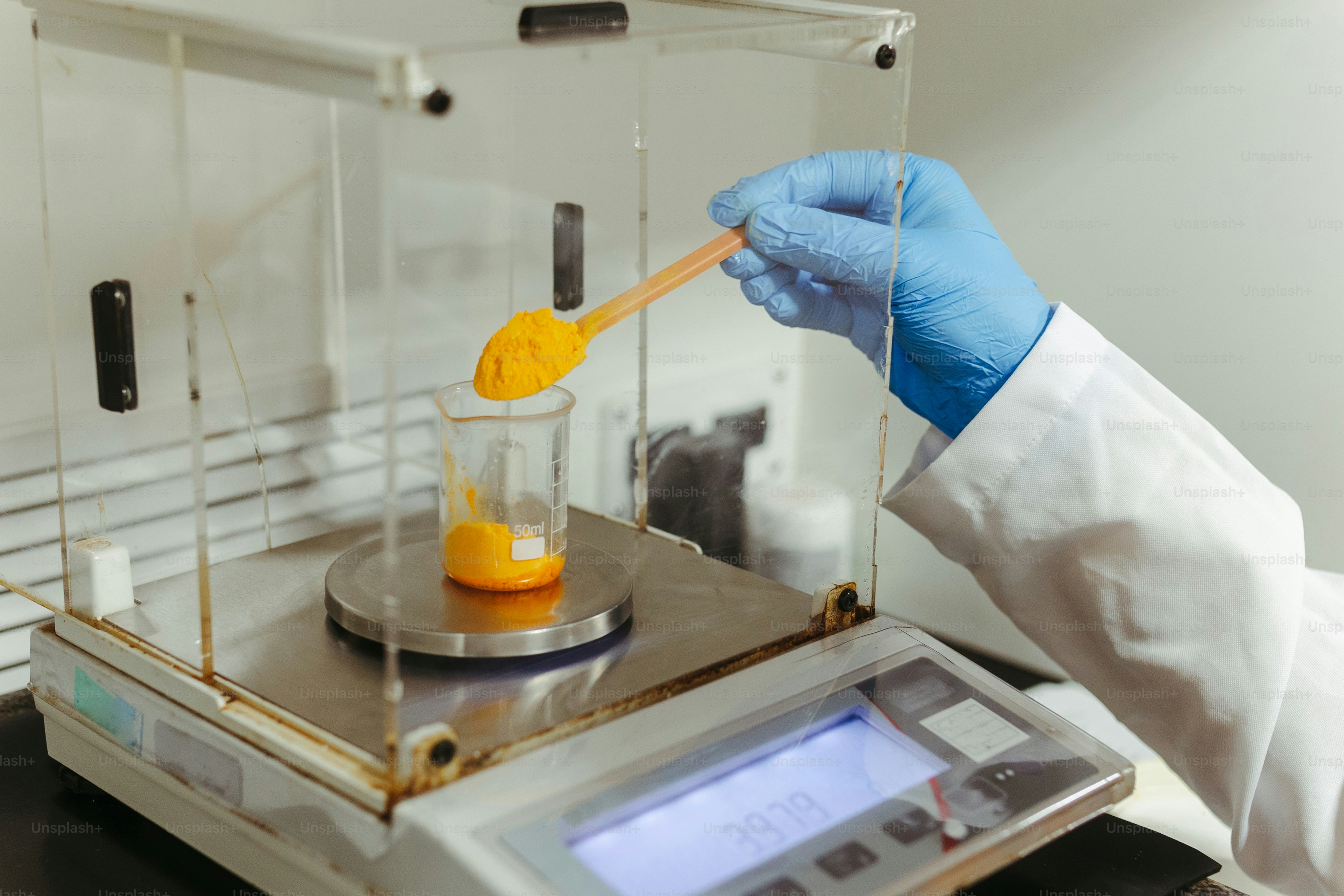 a person in a white lab coat is holding a wooden spoon