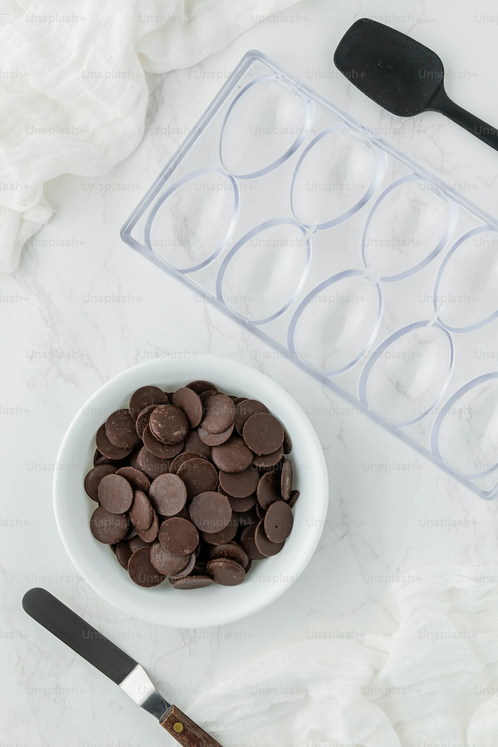 a bowl of chocolate chips next to an ice tray