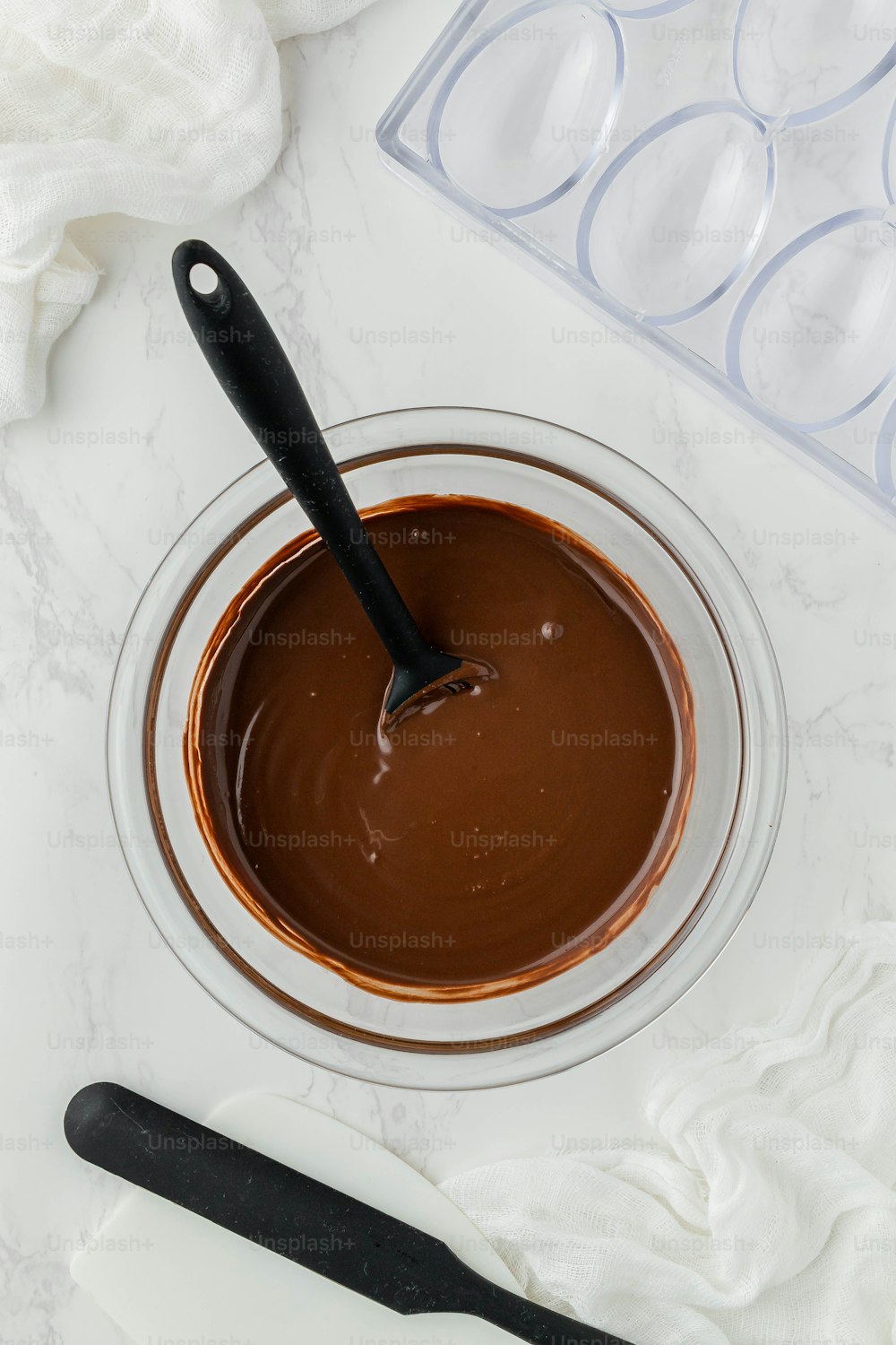 a bowl of melted chocolate with a spoon in it