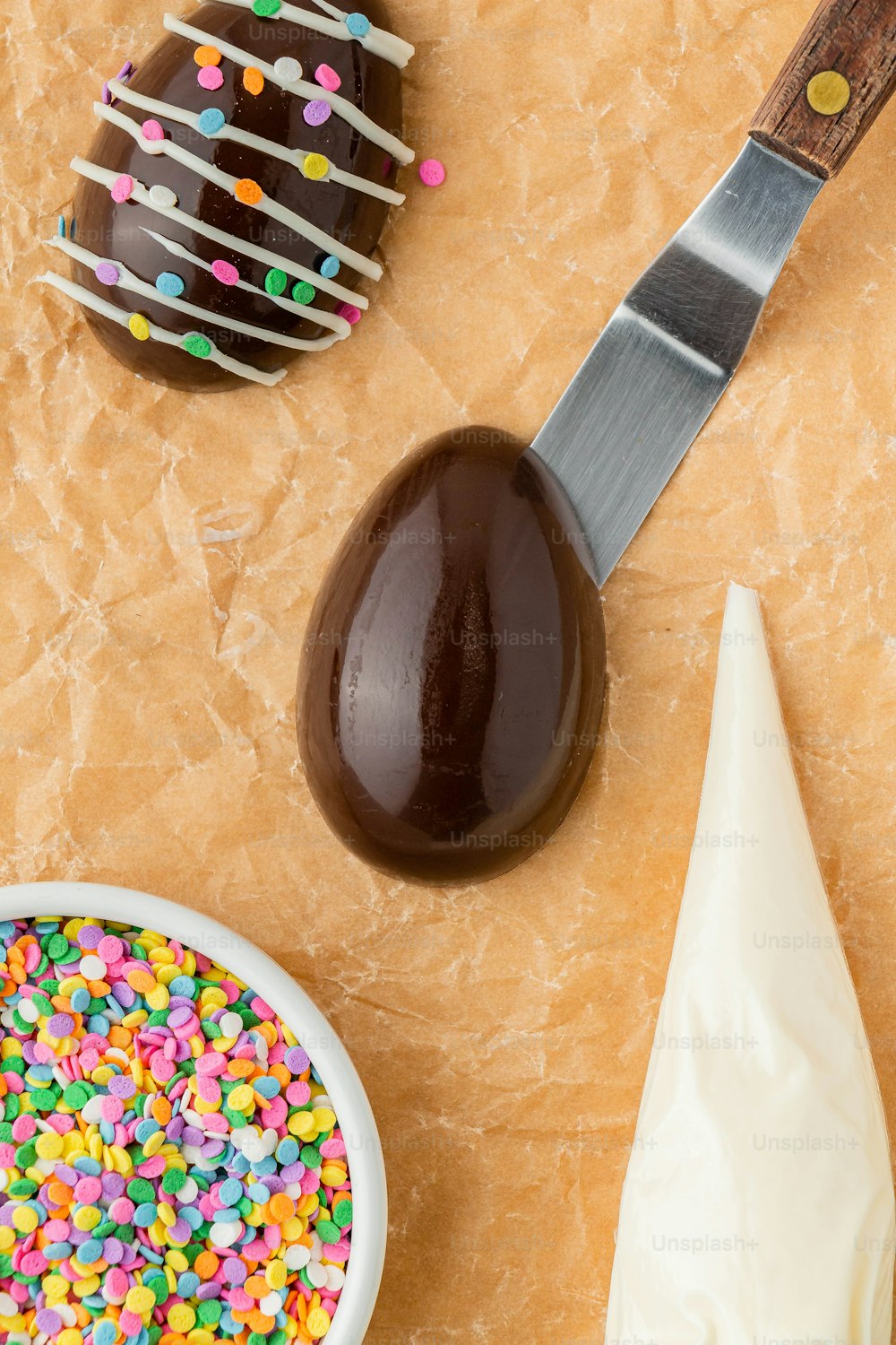 a table topped with a chocolate egg covered in sprinkles
