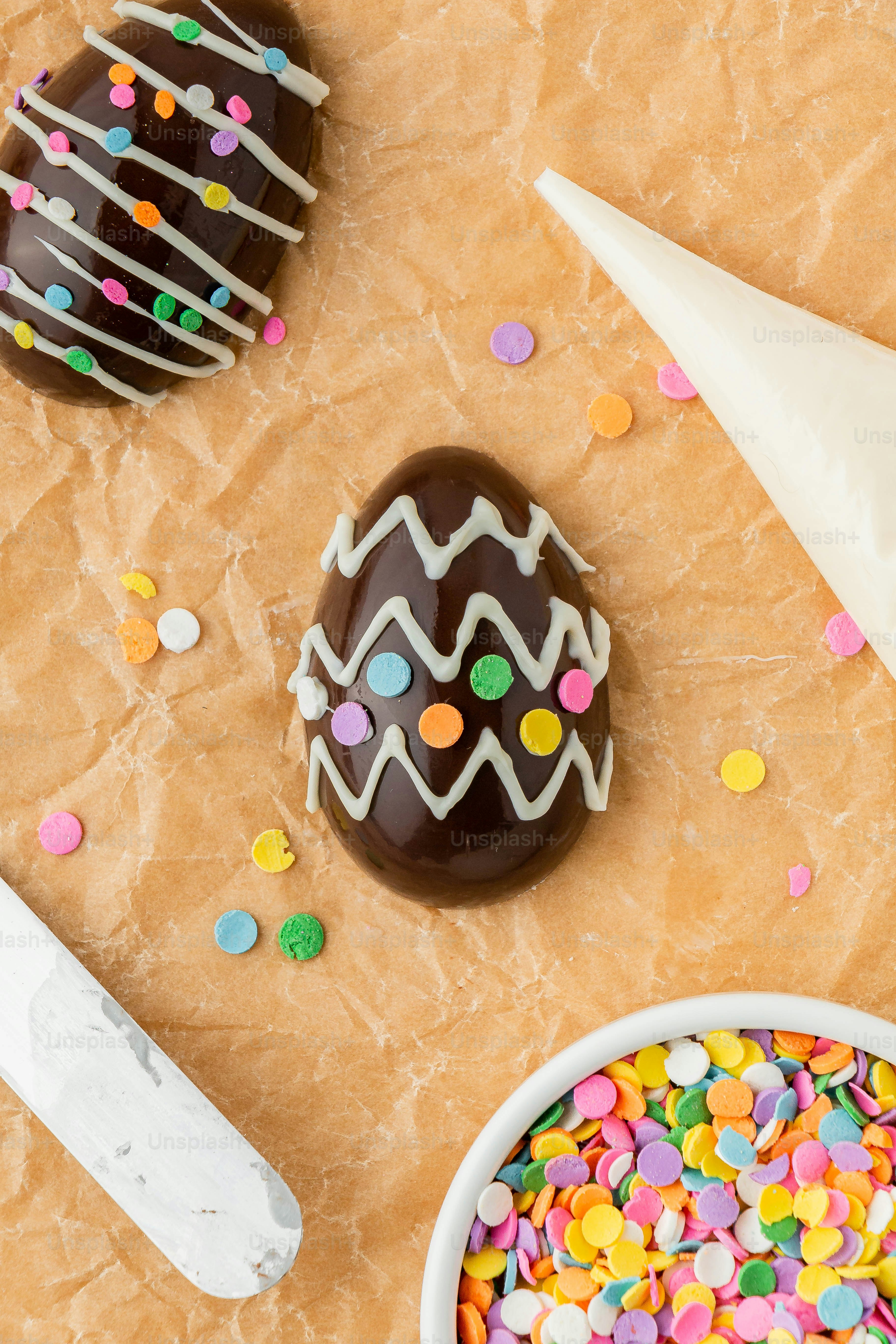 a table topped with chocolate covered donuts and sprinkles