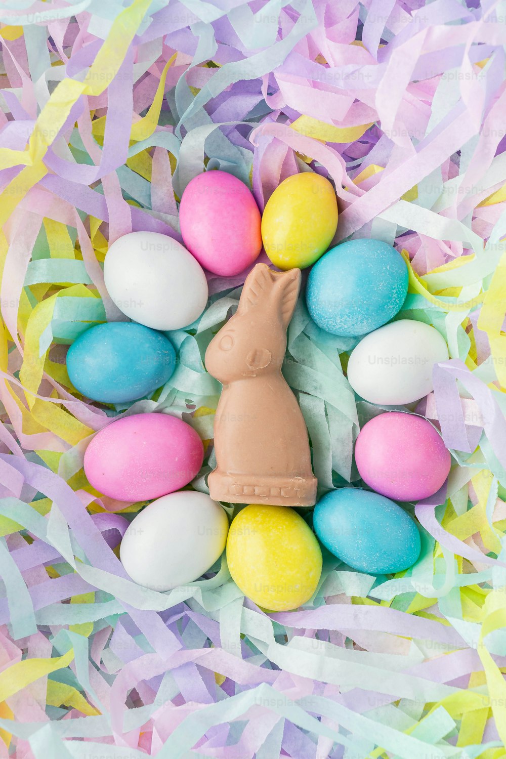 a chocolate bunny in a basket of easter eggs
