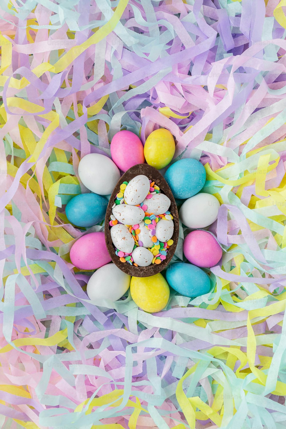 a chocolate easter egg with sprinkles and colored eggs