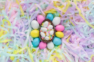 an overhead view of a chocolate easter egg surrounded by colorful streamers