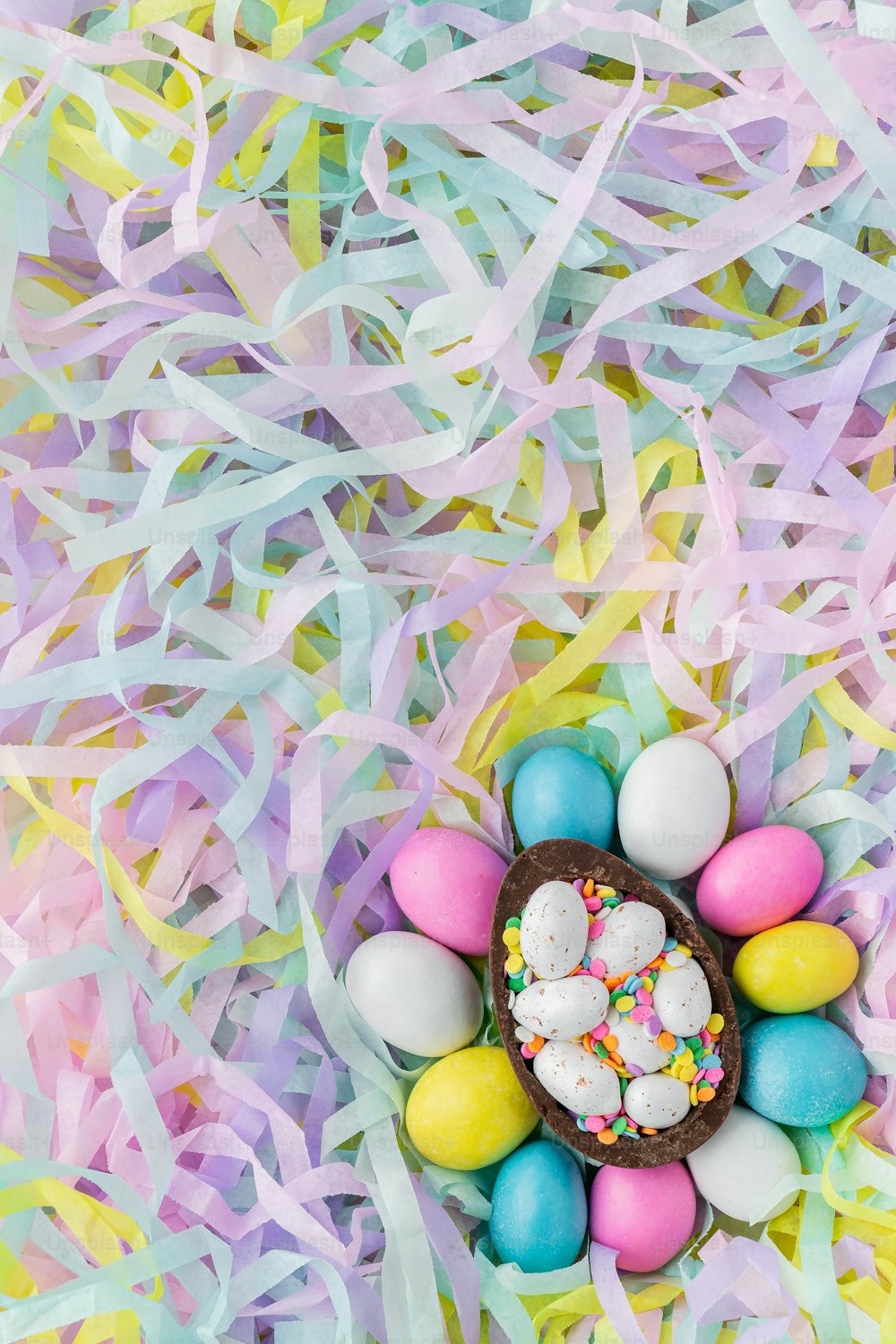 an overhead view of a basket filled with eggs and sprinkles