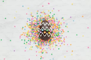 a decorated chocolate egg surrounded by sprinkles